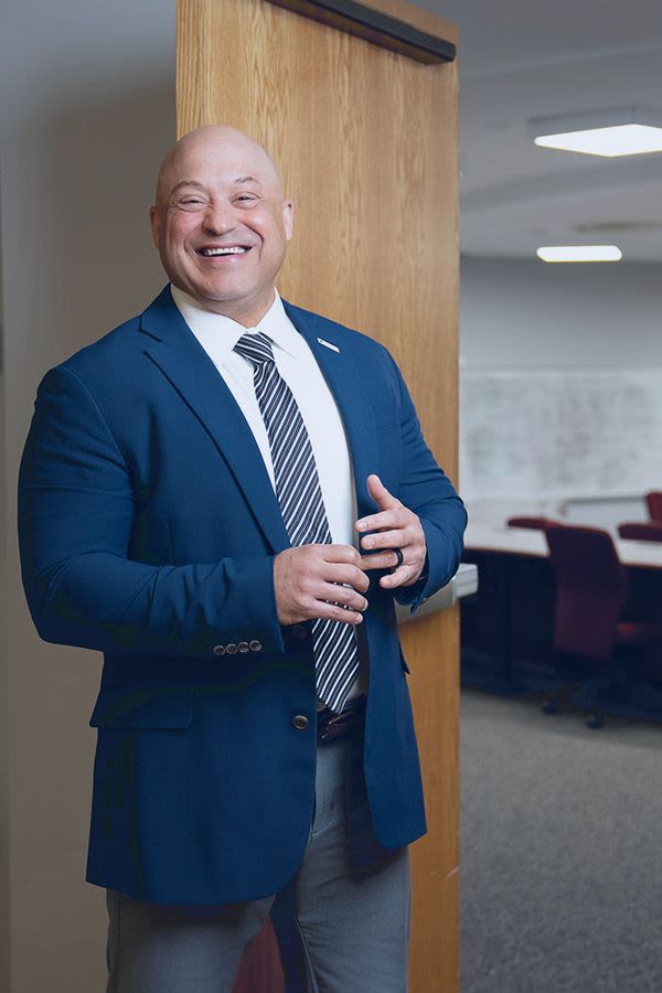 Professor Burton stands in front of a classroom door